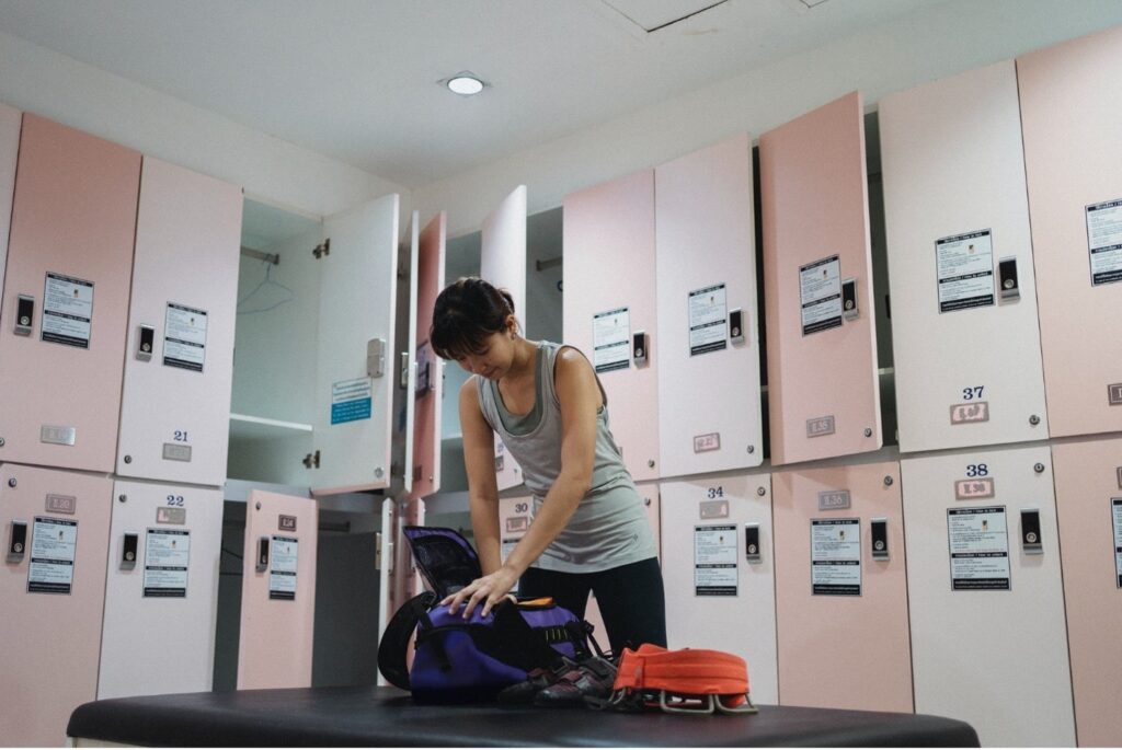 Young lady preparing footwear and gear for climbing training in gym. Photo by Allan Mas from Pexels